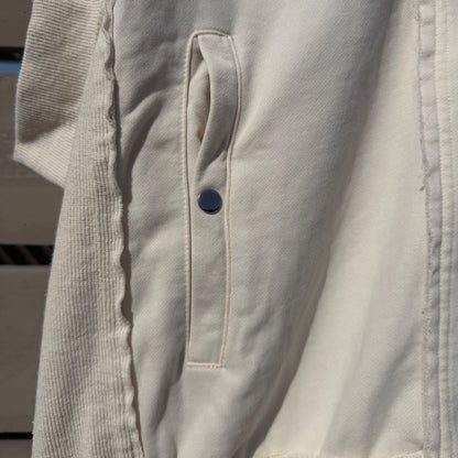 Close-up of a white jacket with a button on a blurred background