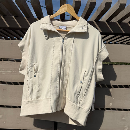 White jacket on a hanger against a wooden fence with blue sky background