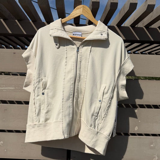 White jacket on a hanger against a wooden fence with blue sky background